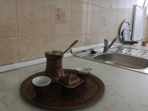 a tray with two cups and a tea pot on a counter at Holiday Home Iman in Sarajevo