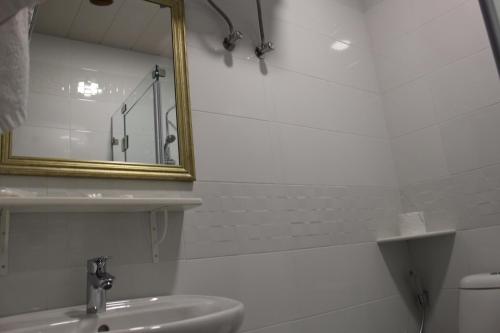 a bathroom with a sink, toilet and mirror at Boutique Hotel 32 in Batumi