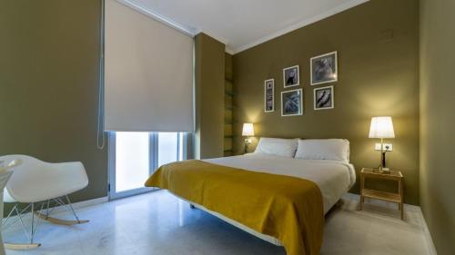 a bedroom with a large bed with a yellow blanket at La Morella del Carmen in Valencia