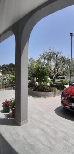 a red car parked in a parking lot at Apartman, studio and room Kata in Pula