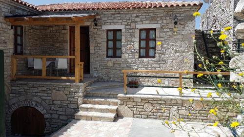 a stone house with a porch and stairs in front of it at Villa Olive Old Qeparo in Qeparo