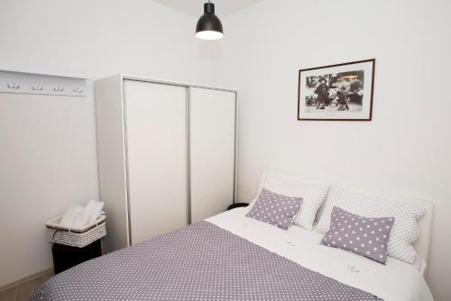 a bedroom with a bed with purple and white pillows at Old Town Apartment Split in Split