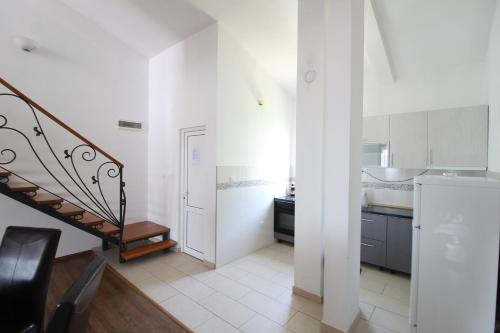 a white kitchen with a staircase and a sink at Apartment Dasic in Bar