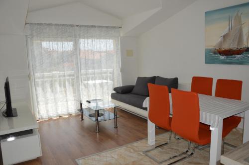 a living room with a couch and a table and chairs at Apartments Babic in Podstrana