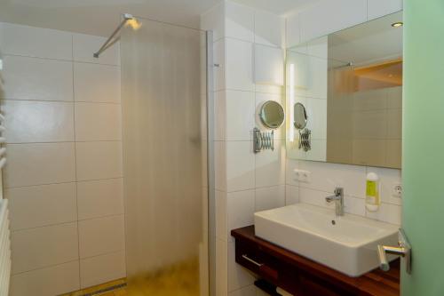 a bathroom with a sink and a shower with a mirror at Landgasthof Zur Post in Schwangau