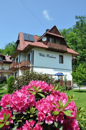 a building with pink flowers in front of it at Willa Parkowa in Szczawnica
