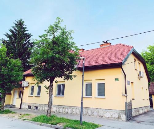 a yellow house with a red roof at LINA ROOMS in Ljubljana