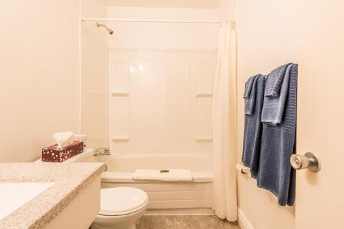 a white bathroom with a toilet and a sink at Lake City Motel in Halifax
