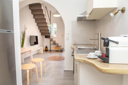 a kitchen with a sink and a counter with stools at Thea Suites Naxos in Agios Prokopios
