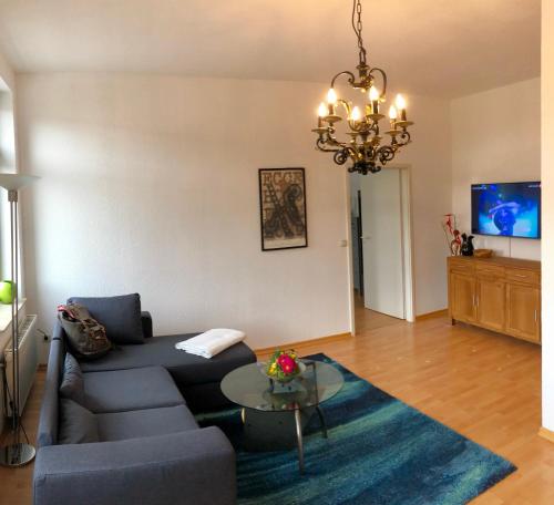 uma sala de estar com um sofá azul e uma mesa em Kaßberg-Apartment am Puls der Stadt em Chemnitz