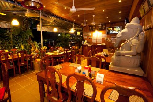 a restaurant with a large statue of a bear sitting on a table at Okay Guesthouse Phnom Penh in Phnom Penh