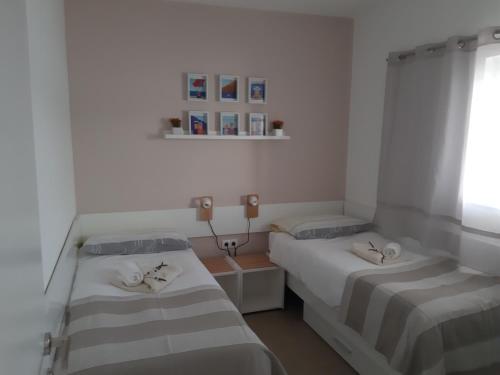 a room with two beds and a window at Beach Apartment More in Seget Vranjica