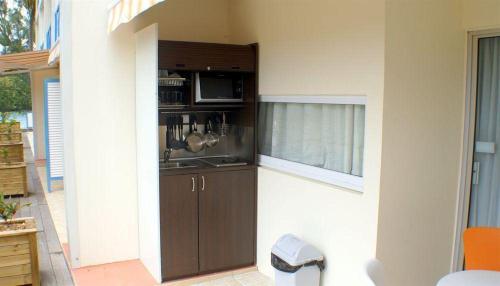 a kitchen with a sink and a microwave at CoCoKreyol - Ti CARAYOU in Les Trois-Îlets