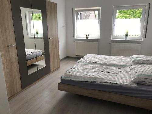1 dormitorio con cama y espejo en Apartment Perla, en Limburg an der Lahn