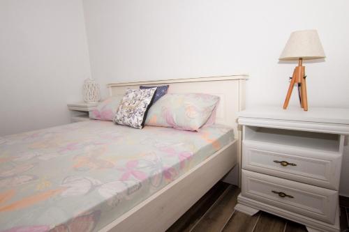 a small bedroom with a bed and a night stand at Banjo Rustic House Lake view in Virpazar