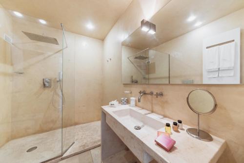 a bathroom with a sink and a shower and a mirror at Giovì Relais in Polignano a Mare