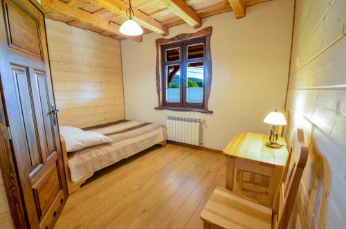 a bedroom with a bed and a window and a table at Dom Gościnny BIERWIONO in Cisna