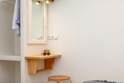 a bathroom with a shelf and a pair of glasses on the wall at Thea Suites Naxos in Agios Prokopios