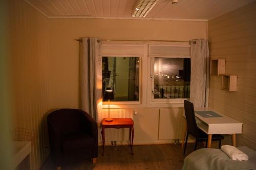Zimmer mit einem Fenster, einem Tisch und einer Lampe in der Unterkunft Varangertunet bed & breakfast in Jakobselv