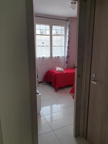 a bedroom with a red bed and a window at B&B Circuit in Borgo San Lorenzo