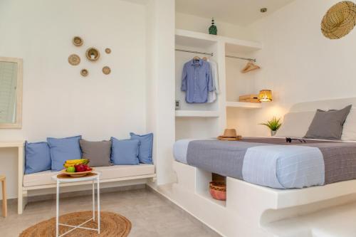 a bedroom with a bed with blue pillows and a table at Thea Suites Naxos in Agios Prokopios