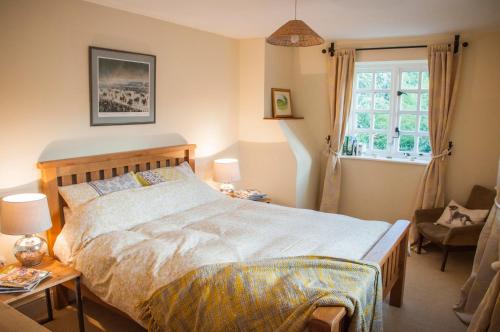 Un dormitorio con una cama grande y una ventana en Milton Farm en East Knoyle