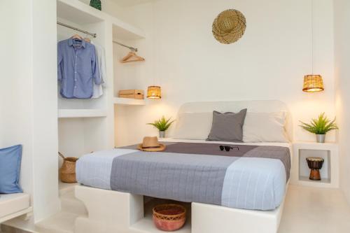 a bedroom with a bed in a white room at Thea Suites Naxos in Agios Prokopios