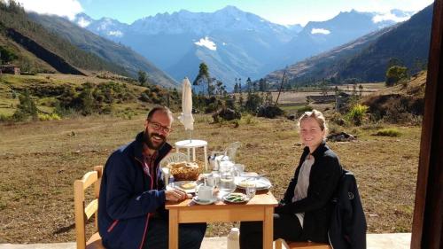 a man and a woman sitting at a table with food at CasaNostra Choquequirao in Cachora