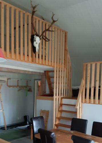 a room with a staircase with a cow head on the wall at Ladan in Katrineholm