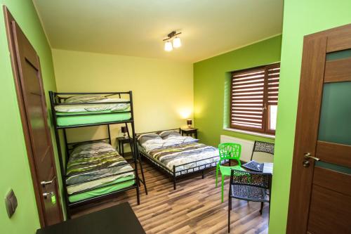2 łóżka piętrowe w pokoju z zielonymi ścianami w obiekcie Willa Potoczki w Istebnej