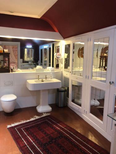 La salle de bains blanche est pourvue d'un lavabo et de toilettes. dans l'établissement VILLA la GLORIETTE, à Rouen