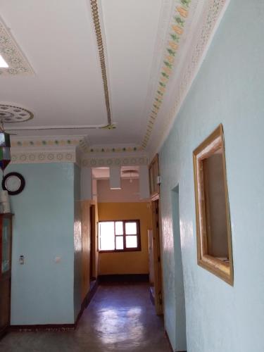 a hallway with a white ceiling and a window at Maison D'hote Amazir in Boumalne