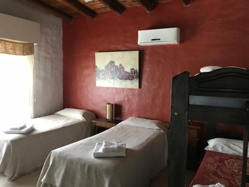 2 camas en una habitación con paredes rojas en Finca Silvestre en San Rafael