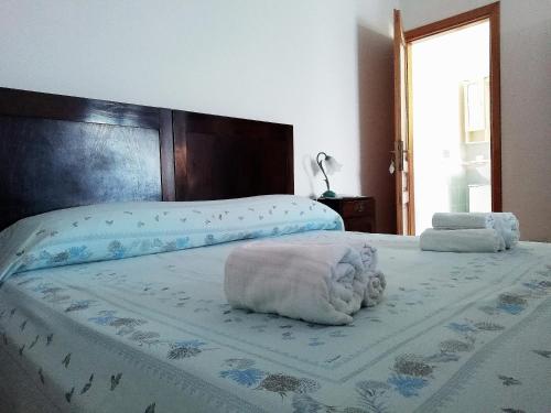 Una cama con dos toallas encima. en Casa di Eugenia en Loceri