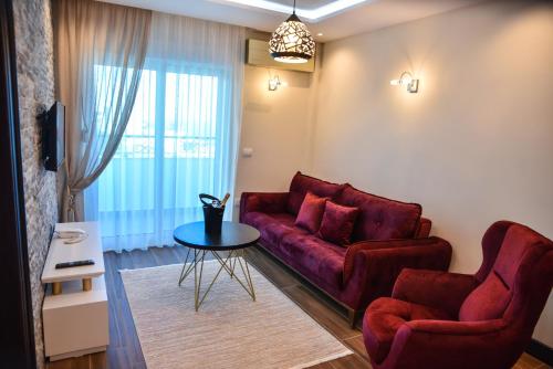 a living room with a red couch and a table at Padam Hotel & SPA in Ulcinj