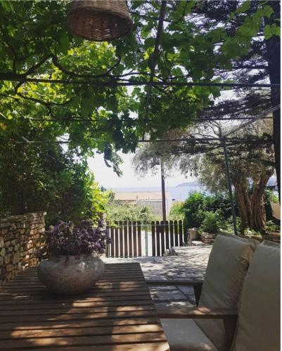 a patio with a chair and a vase of flowers at Greekowl apartments in Skiathos Town