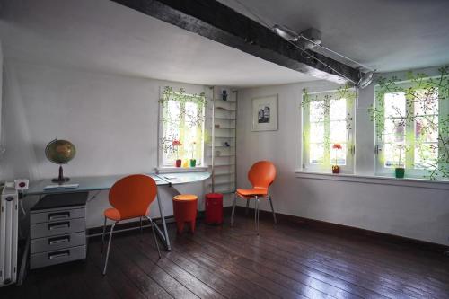a room with two chairs and a desk and windows at Hexenhäuschen Dreieichenhain in Dreieich