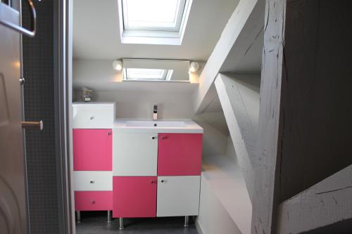 La salle de bains est pourvue d'une armoire rouge et blanche ainsi que d'un lavabo. dans l'établissement Rooftop grande terrasse jacuzzi vue mer, à Cannes