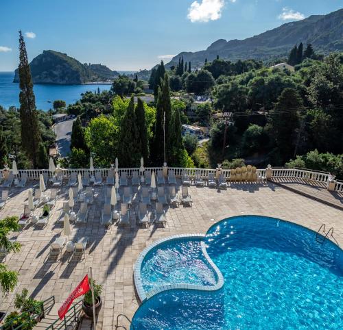 a swimming pool with chairs and a view of a lake at Paleo ArtNouveau Hotel - Adults Only in Paleokastritsa