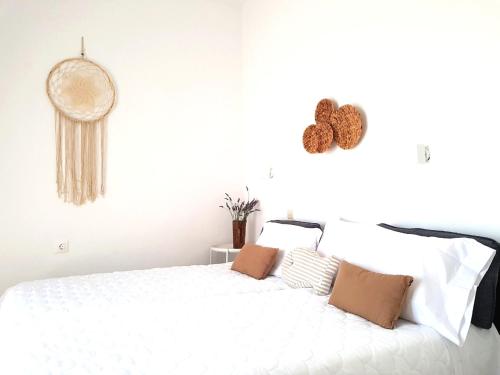 una camera da letto con letto bianco e cuscini marroni di Greekowl apartments a Città di Skiathos
