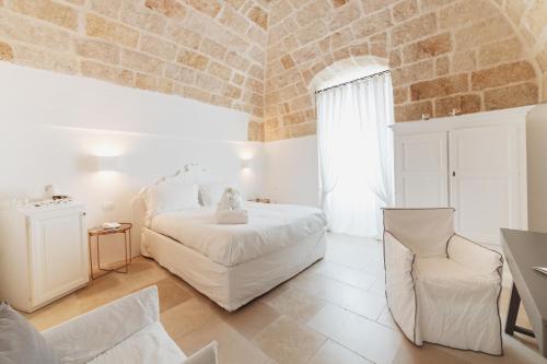 a bedroom with two beds and a stone wall at Giovì Relais in Polignano a Mare