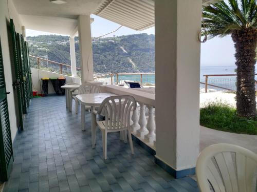 a porch with a table and chairs and the ocean at La Dea del Mare in Ischia