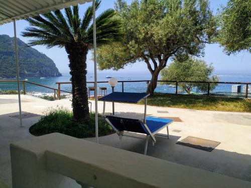 a table and a chair on a patio with a view of the ocean at La Dea del Mare in Ischia