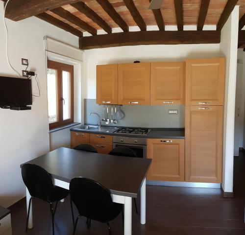 a kitchen with wooden cabinets and a table and chairs at B&B Capo Pero in Rio Marina
