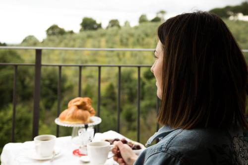 a woman sitting at a table with a plate of food at Bellavalle ROOMS Vinci Florence Tuscany in Vinci