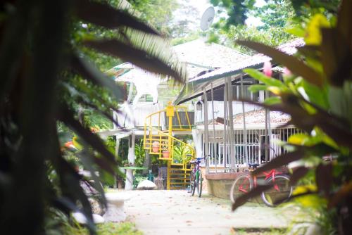 a house with a bike parked in front of it at Madre Selva Hostel in Puerto Viejo