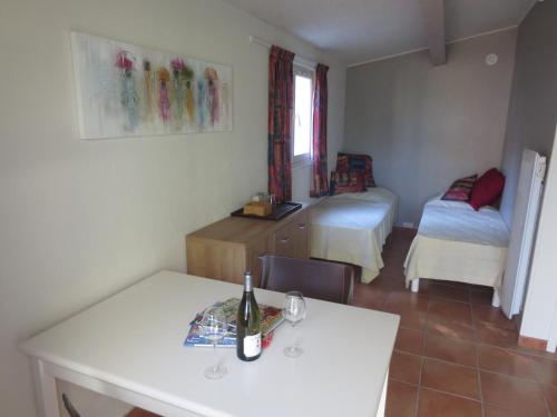 a room with two beds and a table with a bottle of wine at Chevalier in Saint-Nazaire