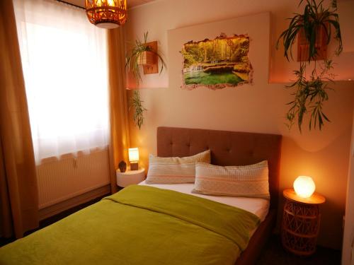 Schlafzimmer mit einem Bett mit grüner Bettwäsche und einem Fenster in der Unterkunft Ferienwohnung Wusterwitz in Wusterwitz
