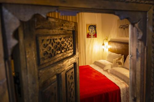 a small bedroom with a bed with a red blanket at Attico rooms in Giardini Naxos