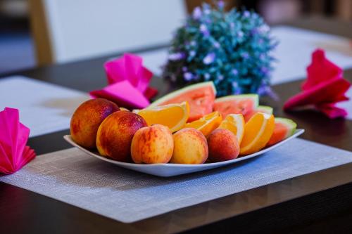a plate of fruit sitting on a table at Boutique Hotel's III Piłsudskiego in Łódź